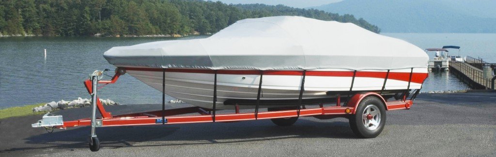 red and white boat covered beside a lake