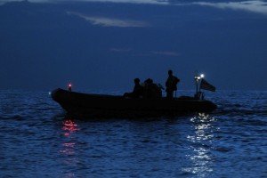 US Navy inflatable on the water at night with the nav lights on