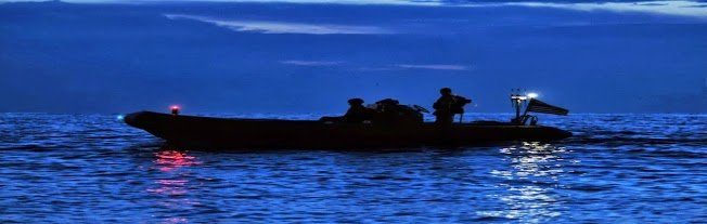 Navy inflatable boat on water at night