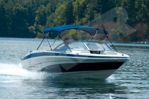 man driving boat on lake with Bimini top up