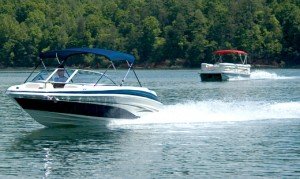 Blue Bimini Top on Runabout and Red Bimini on Pontoon in Background. On the water shot