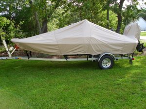 Side View of a trailered Carolina Skiff JV 17 CC with a beige Carver Performance Poly-Guard boat cover